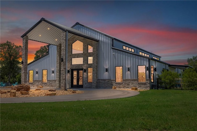 1923 County Road 202, Caldwell, TX 77836 - view of front of property featuring board and batten siding, french doors, a front yard, and stone siding