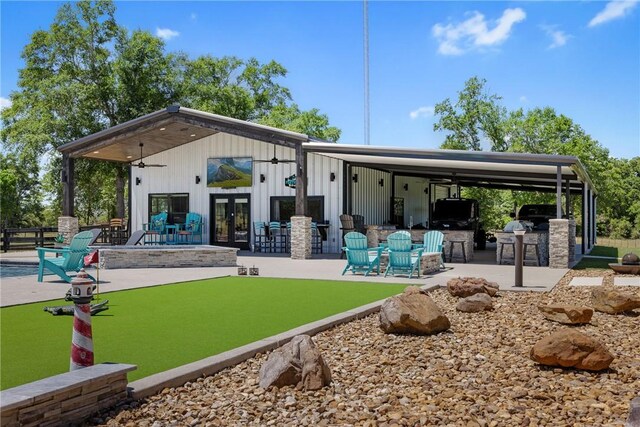 1923 County Road 202, Caldwell, TX 77836 - back of property featuring area for grilling, french doors, a patio, board and batten siding, and exterior bar