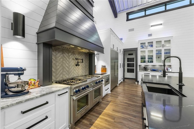 1923 County Road 202, Caldwell, TX 77836 - kitchen featuring range with two ovens, a sink, white cabinetry, and tasteful backsplash