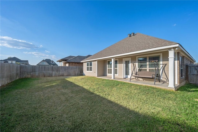 rear view of property with a patio area and a yard