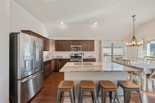 kitchen featuring a healthy amount of sunlight, stainless steel appliances, and lofted ceiling