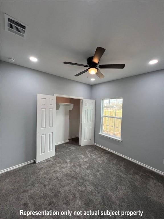 unfurnished bedroom with dark carpet, a closet, and ceiling fan