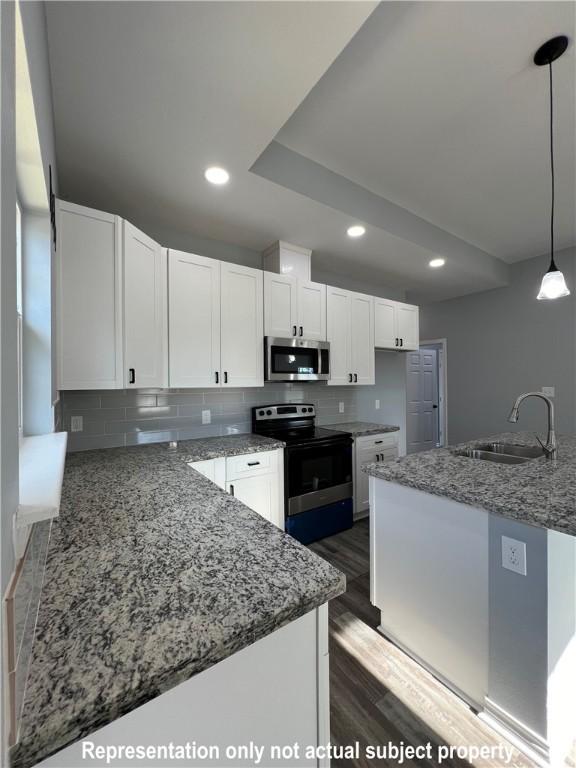 kitchen featuring sink, white cabinetry, range with electric cooktop, and hanging light fixtures