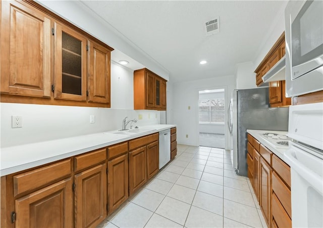 kitchen with sink, light tile patterned floors, premium range hood, and dishwasher