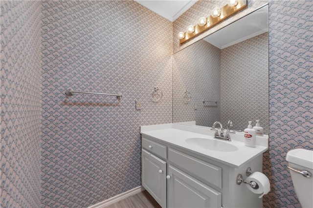 bathroom with crown molding, vanity, and toilet