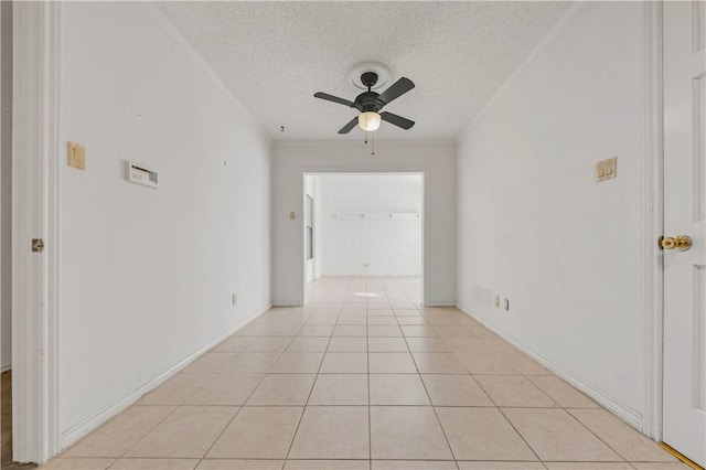 spare room featuring light tile patterned flooring, crown molding, ceiling fan, and a textured ceiling