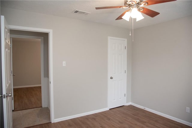 3023 Kim St, Bryan, TX 77803 - unfurnished bedroom featuring wood finished floors, baseboards, ceiling fan, and a closet
