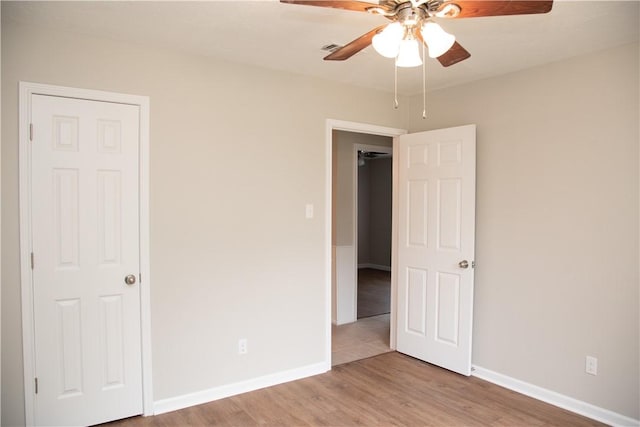 3023 Kim St, Bryan, TX 77803 - unfurnished bedroom with wood finished floors, baseboards, and a ceiling fan