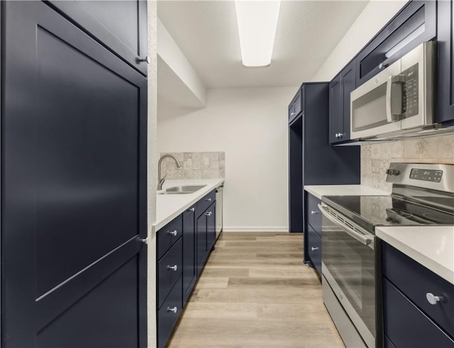 kitchen with light hardwood / wood-style flooring, sink, stainless steel appliances, and backsplash