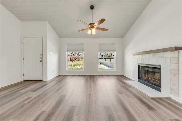 unfurnished living room with ceiling fan, light wood-type flooring, and lofted ceiling