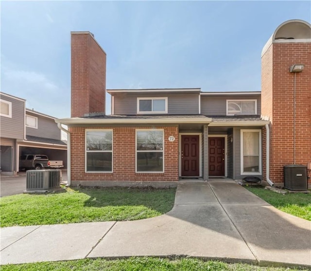 view of front of property with central AC unit and a front yard