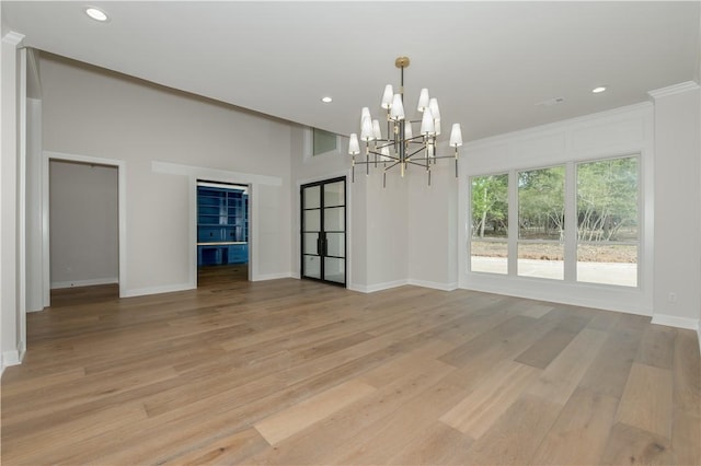 unfurnished dining area featuring light hardwood / wood-style floors, a notable chandelier, and ornamental molding