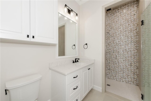 bathroom featuring toilet, vanity, and tiled shower