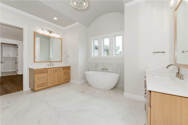 bathroom featuring crown molding, a washtub, and vanity