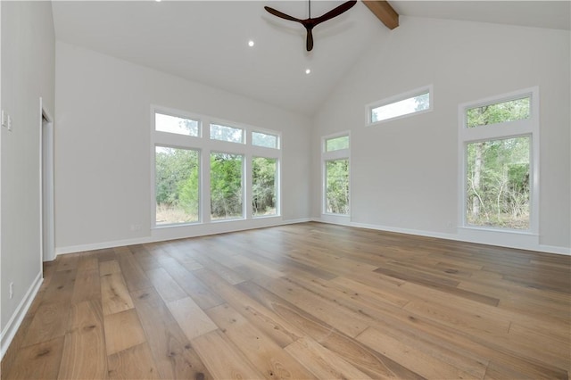 empty room featuring beamed ceiling, high vaulted ceiling, light hardwood / wood-style flooring, and ceiling fan