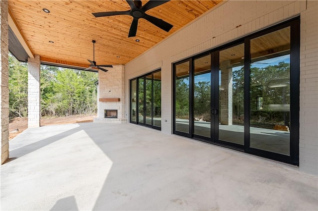 view of patio with french doors, an outdoor brick fireplace, and ceiling fan