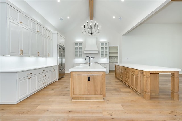 kitchen with white cabinets, a large island with sink, and hanging light fixtures