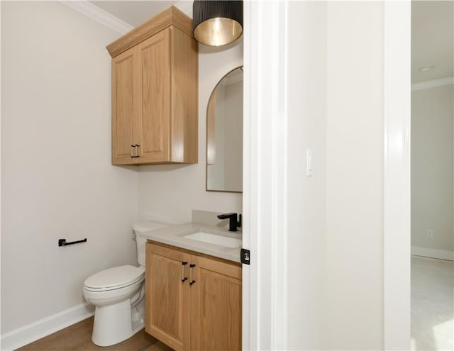 bathroom featuring hardwood / wood-style flooring, vanity, toilet, and ornamental molding