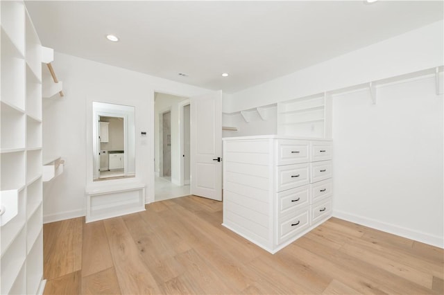 walk in closet with light hardwood / wood-style floors