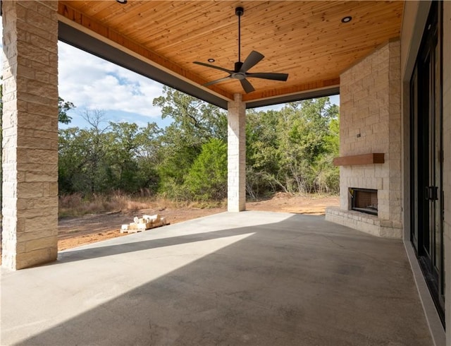 view of patio with ceiling fan and an outdoor stone fireplace