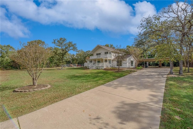 view of front facade featuring covered porch, a front yard, and a carport