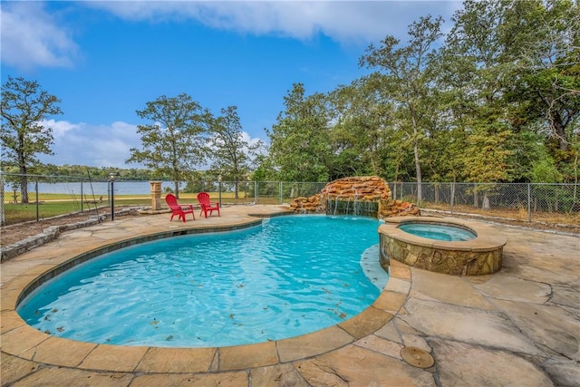 view of pool with pool water feature, a patio area, an in ground hot tub, and a water view