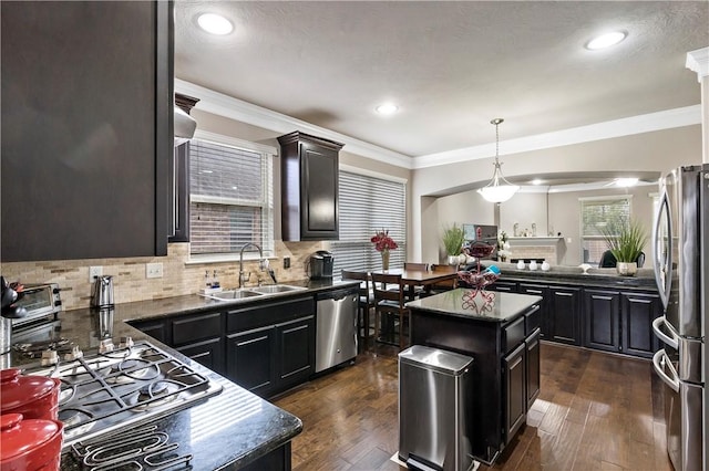 kitchen featuring appliances with stainless steel finishes, dark hardwood / wood-style floors, a kitchen island, and sink