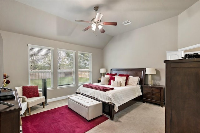 bedroom featuring light colored carpet, vaulted ceiling, and ceiling fan