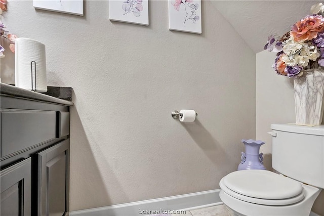 bathroom featuring tile patterned floors, vaulted ceiling, and toilet