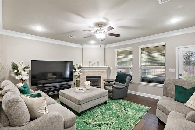 living room featuring ceiling fan, a fireplace, dark wood-type flooring, and ornamental molding