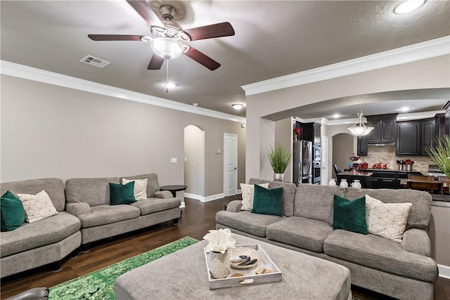 living room with ornamental molding, ceiling fan, and dark wood-type flooring