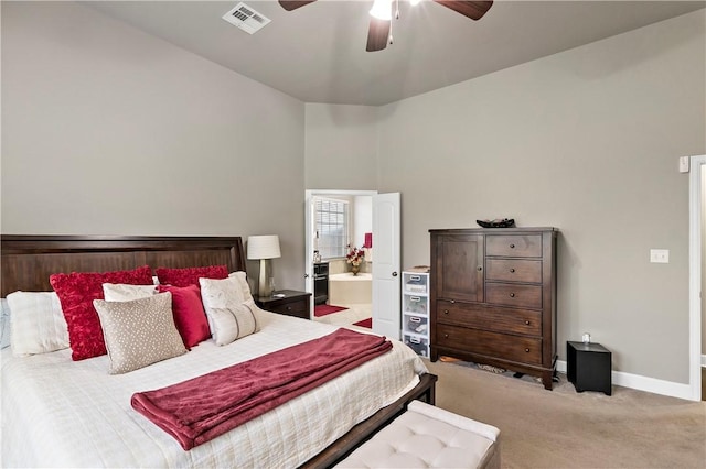 bedroom with light colored carpet, ensuite bath, and ceiling fan