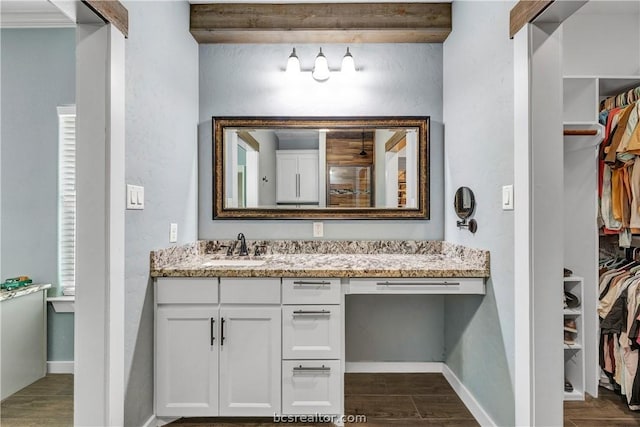 bathroom featuring beamed ceiling, vanity, and hardwood / wood-style flooring