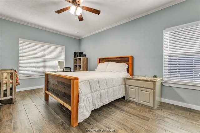 bedroom featuring multiple windows, hardwood / wood-style floors, and ceiling fan