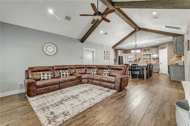 living room featuring vaulted ceiling with beams, dark wood-type flooring, and ceiling fan with notable chandelier