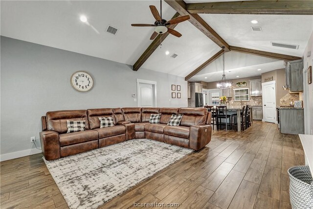 living room featuring vaulted ceiling with beams, dark wood-type flooring, and ceiling fan with notable chandelier