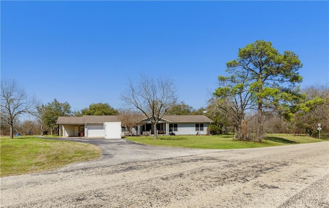 ranch-style house featuring aphalt driveway, an attached garage, and a front yard