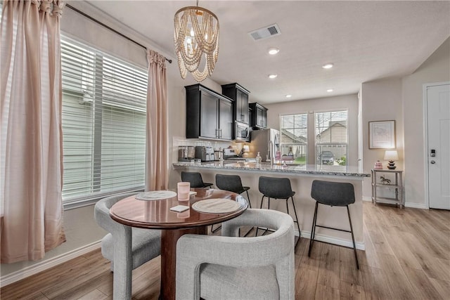 808 Mineral Wells Ln, College Station, TX 77845 - dining space with a chandelier, light wood-type flooring, and recessed lighting