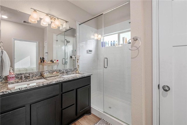 808 Mineral Wells Ln, College Station, TX 77845 - bathroom with double vanity, a shower stall, and wood finished floors