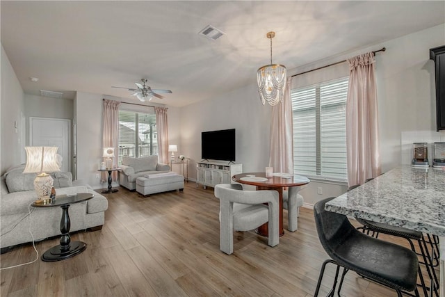 808 Mineral Wells Ln, College Station, TX 77845 - living area featuring light wood finished floors, a ceiling fan, and a chandelier
