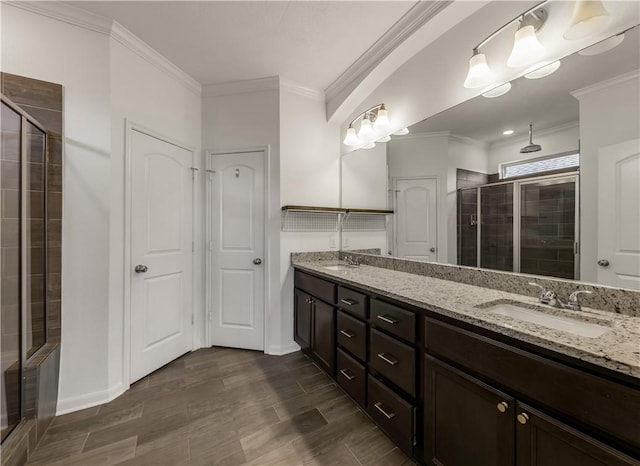 bathroom featuring vanity, crown molding, and a shower with shower door