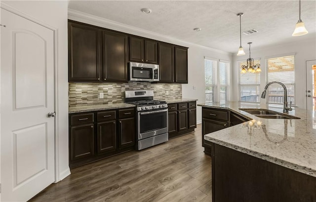 kitchen with pendant lighting, sink, decorative backsplash, dark brown cabinetry, and stainless steel appliances