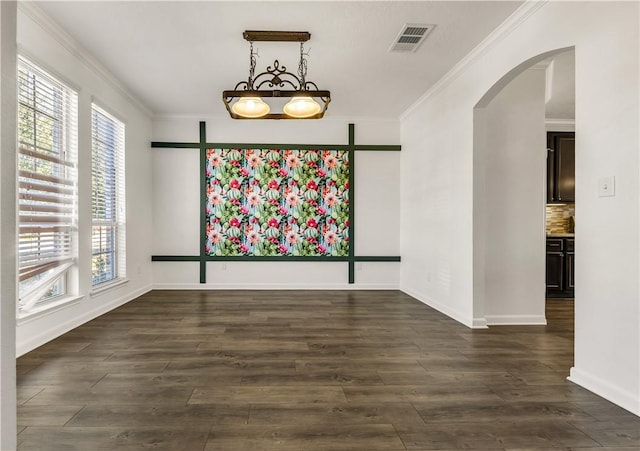 unfurnished dining area with ornamental molding and dark hardwood / wood-style floors