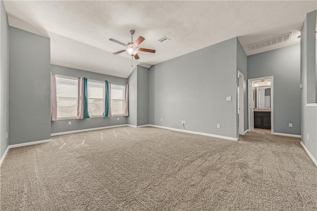 carpeted spare room featuring ceiling fan and lofted ceiling