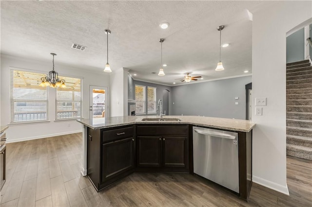 kitchen featuring dishwasher, sink, crown molding, and light stone counters