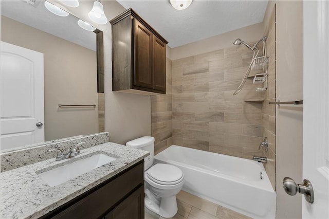 full bathroom with vanity, tile patterned flooring, tiled shower / bath combo, and toilet