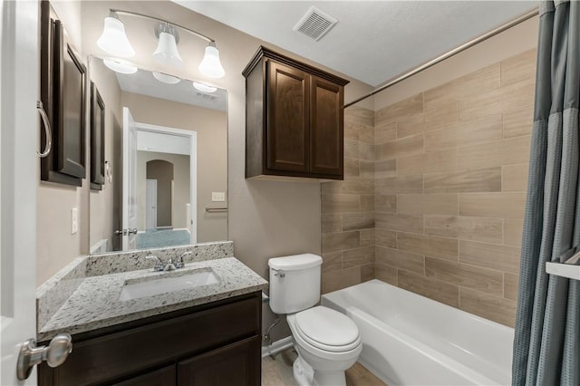 full bathroom featuring vanity, shower / bath combination with curtain, and toilet