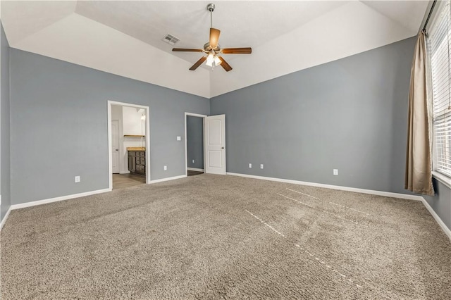 unfurnished bedroom featuring carpet, connected bathroom, lofted ceiling, and ceiling fan