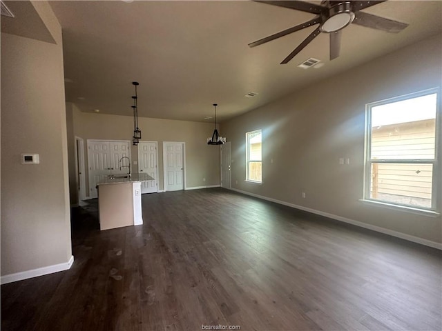 unfurnished living room with ceiling fan, sink, and dark hardwood / wood-style flooring