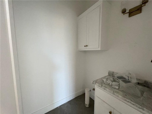 bathroom featuring concrete floors, vanity, and baseboards